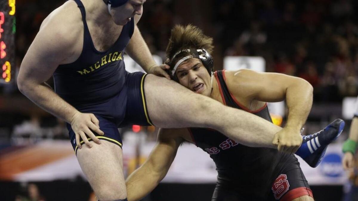 North Carolina State’s Nick Gwiazdowski, right, tries to take down Michigan’s Adam Coon in a 285-pound match during the semifinals of the NCAA Division I wrestling championships Friday. Gwiazdowski won the match and faces Ohio State’s Kyle Snyder tonight for the heavyweight title.