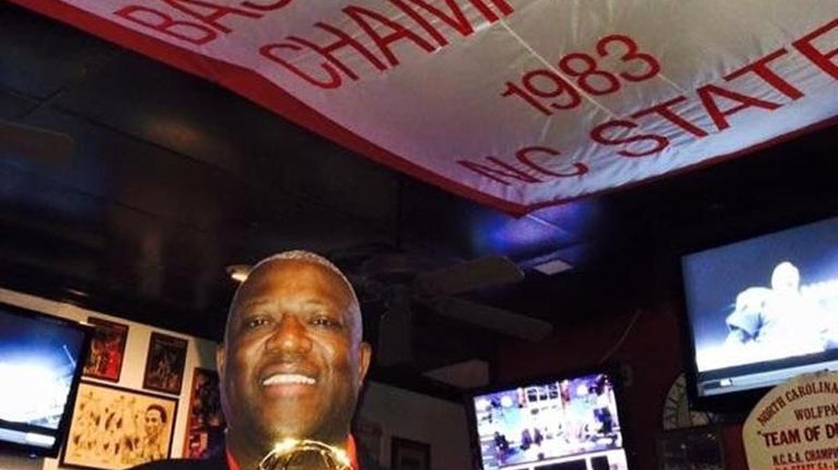 Dereck Whittenburg, of the NC State stars on 1983, stands underneath 1983 banner at Amedeo’s as he display the Emmy won from ESPN’s 30 for 30 documentary “Survive and Advance.”