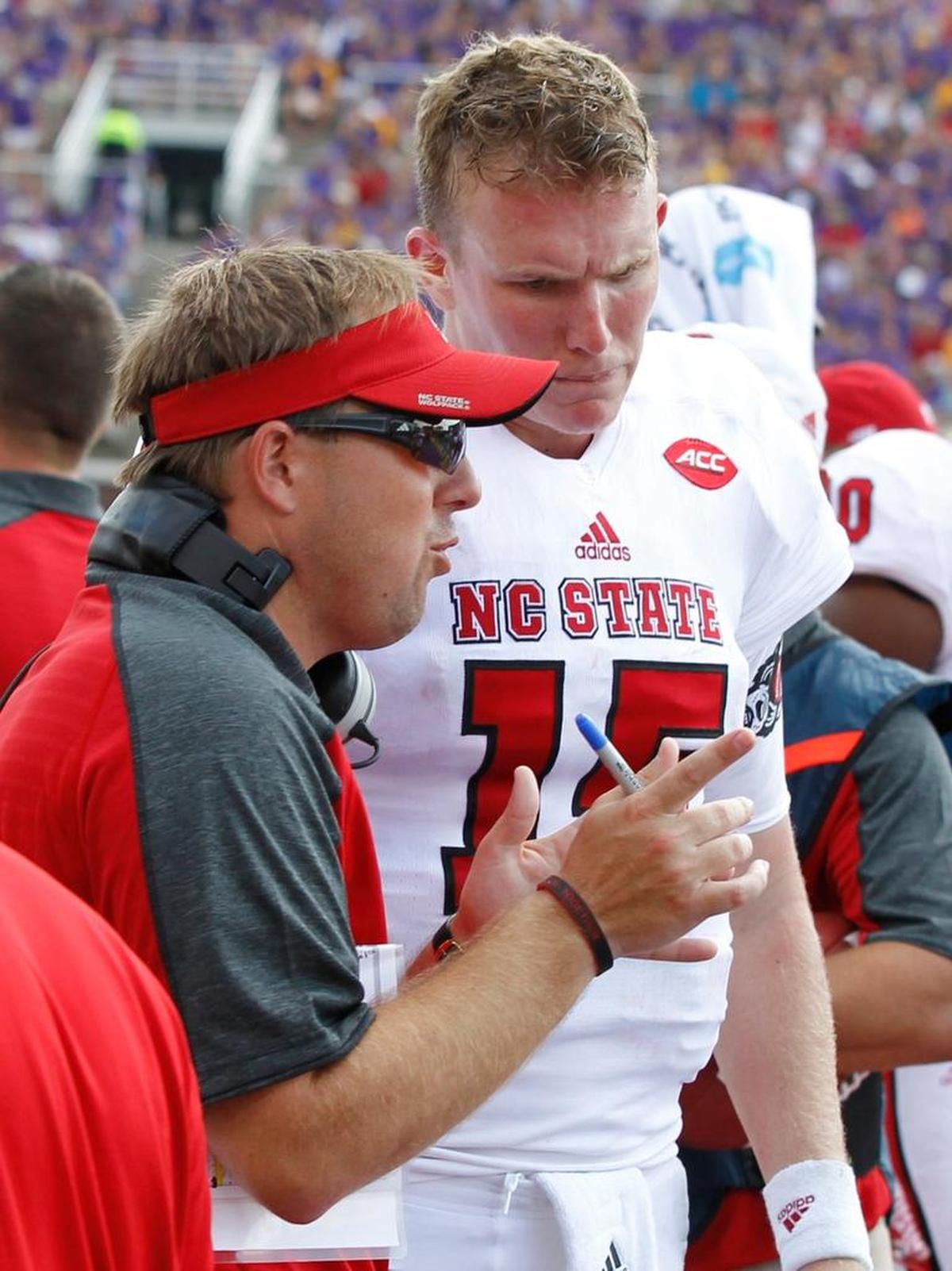 N.C. State offensive coordinator Eli Drinkwitz talks with quarterback Ryan Finley during the second half of ECU’s 33-30 win over the Wolfpack last September.