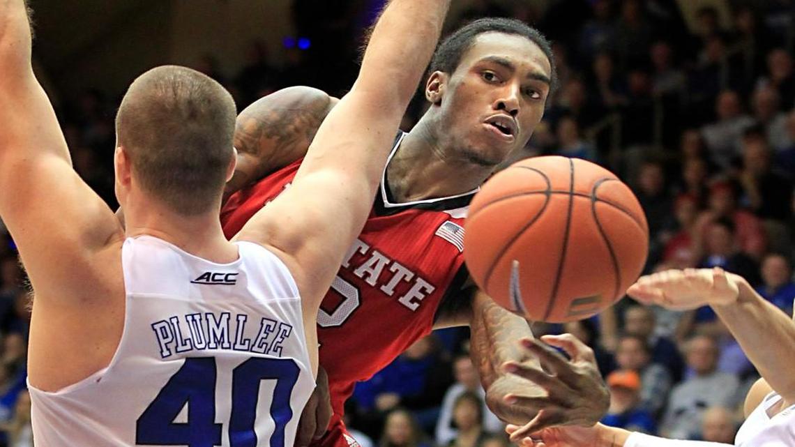 N.C. State's Cat Barber (12) passes around Duke's Marshall Plumlee (40) during the second half of Duke's 88-80 victory over N.C. State at Cameron Indoor Stadium in Durham, N.C., Saturday, Feb. 6, 2016.
