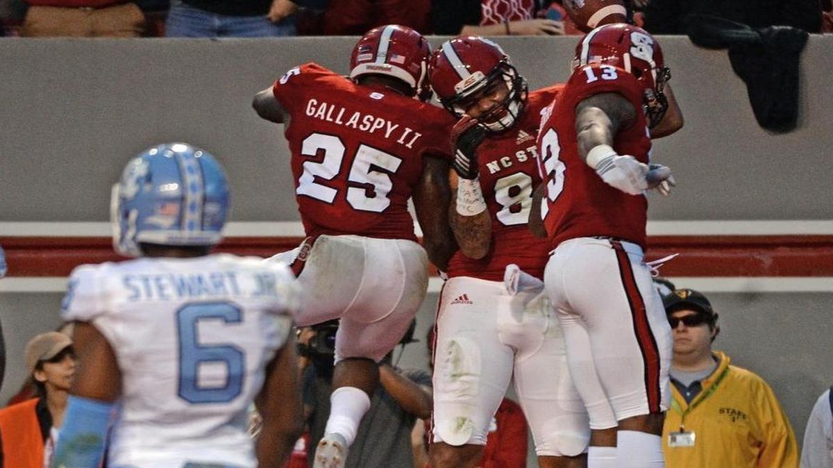 N.C. State tight end David J. Grinnage (86) celebrates with teammates running back Reggie Gallaspy II (25) and wide receiver Bra'Lon Cherry (13) as he scores at the end of the second quarter at Carter Finley Stadium in November.