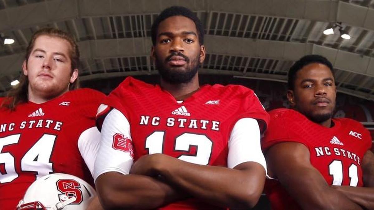 From left, N.C. State's Joe Thuney, Jacoby Brissett, and Justin Burris have their photo taken at the Close-King Indoor Practice Facility in Raleigh on August 3.