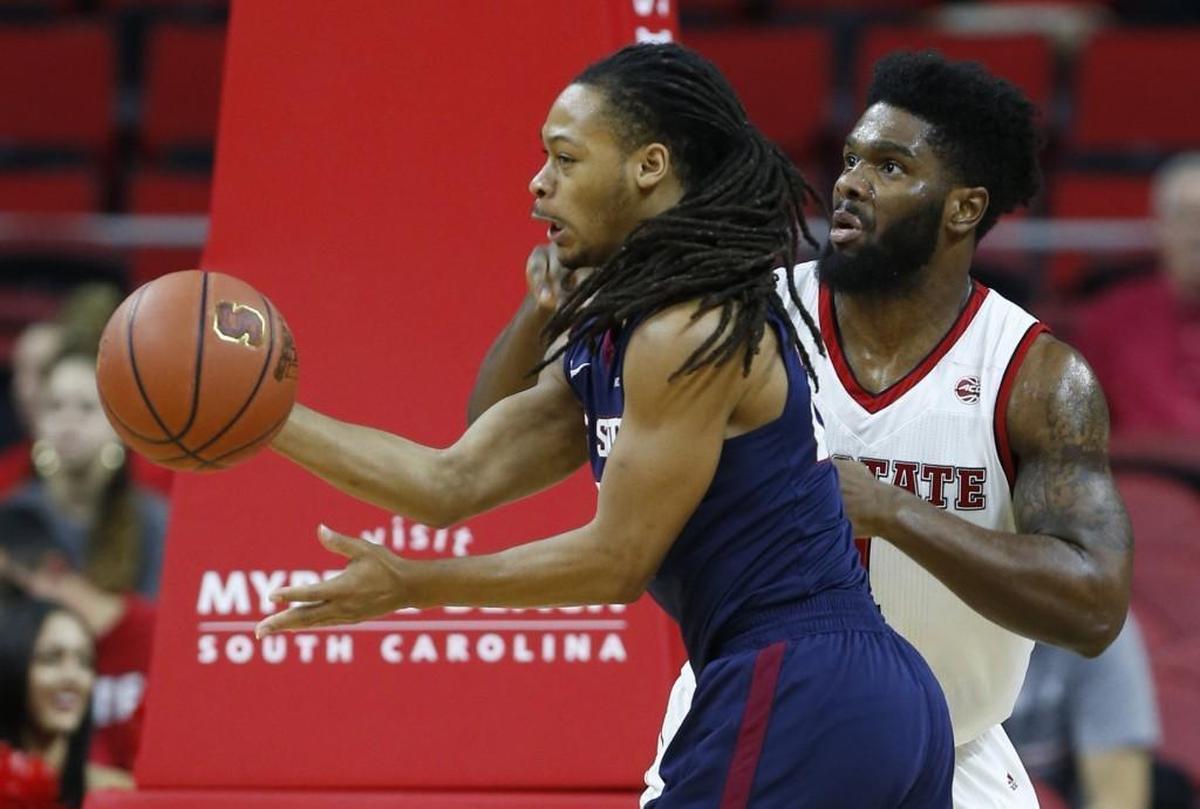 South Carolina State's Tyvoris Solomon (23) passes the ball away from the pressure by N.C. State's Lennard Freeman (1) during the first half of N.C. State's game against South Carolina State at PNC Arena on Dec. 2, 2017.