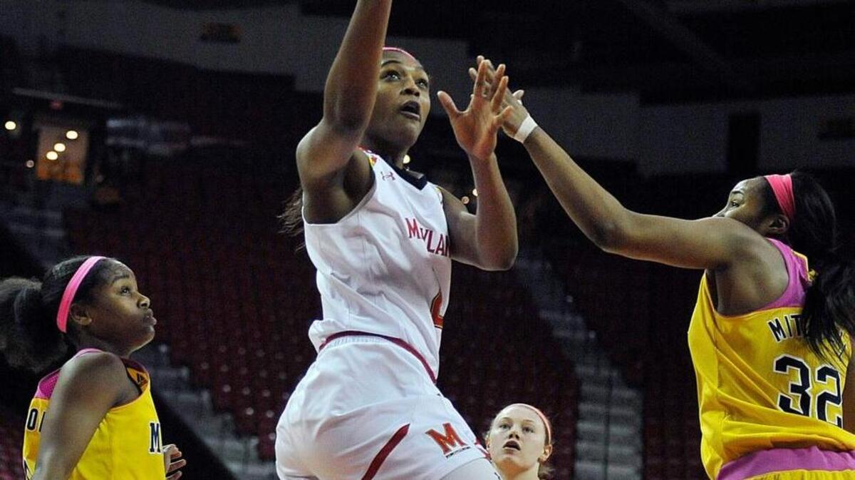Maryland’s Kiara Leslie shoots between Michigan's Sierra Thompson, left, and Kelsey Mitchell, right, during the second half of an NCAA college basketball game, Wednesday, Feb. 17, 2016, in College Park, Md. Maryland won 76-56. (AP Photo/Gail Burton)