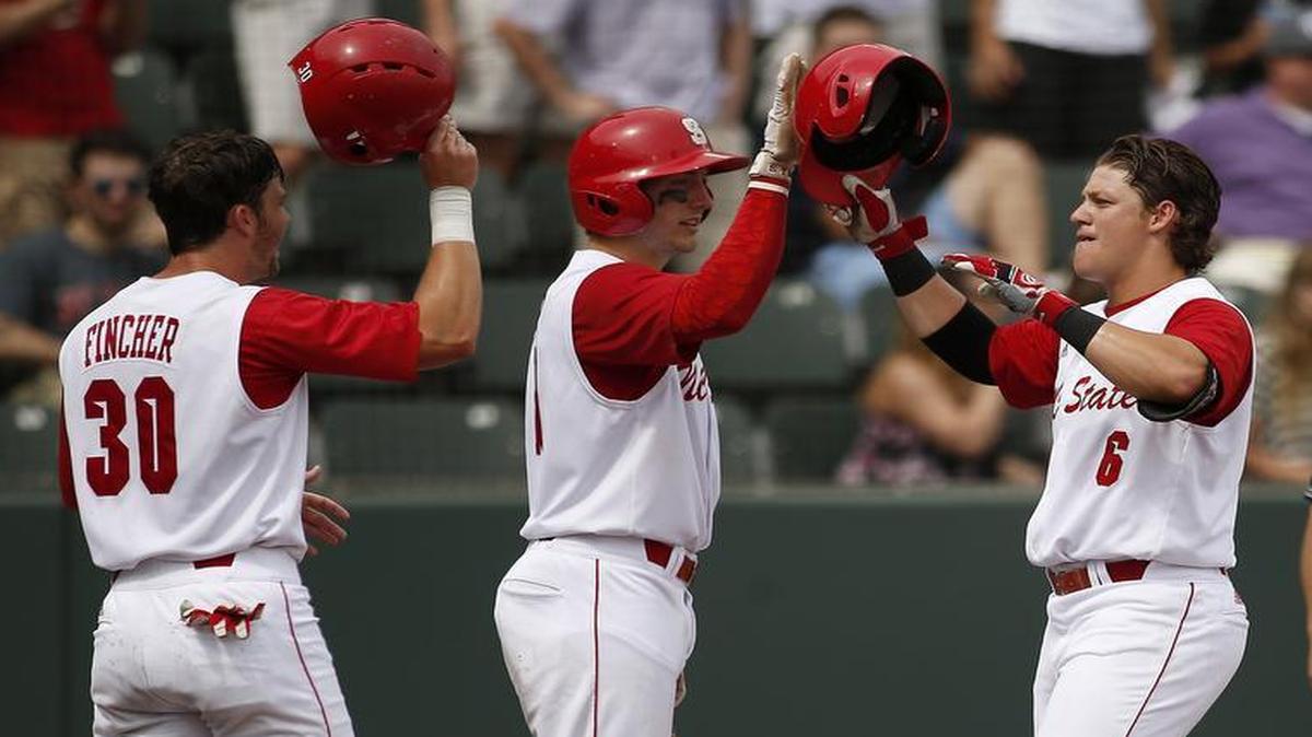 
N.C. State's Logan Ratledge (6) is met at home plate by teammates Jake Fincher, left, and Andrew Knizner, middle, after hitting a two-run home run in the fifth inning against Stony Brook at the Fort Worth Regional of the NCAA college baseball tournament in Fort Worth, Texas, on Friday, May 29, 2015. N.C. State won 3-0. 
