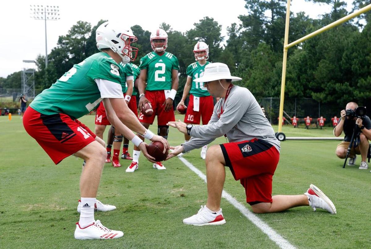 N.C. State offensive coordinator Eli Drinkwitz works with quarterback Ryan Finley during the Wolfpack’s first practice in July.