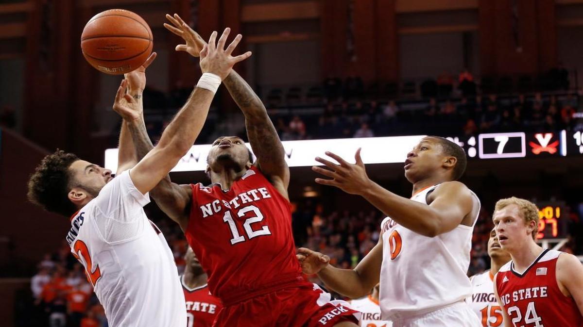 N.C. State’s Cat Barber is fouled by Virginia’s London Perrantes (32) while shooting the ball in the first half at John Paul Jones Arena.