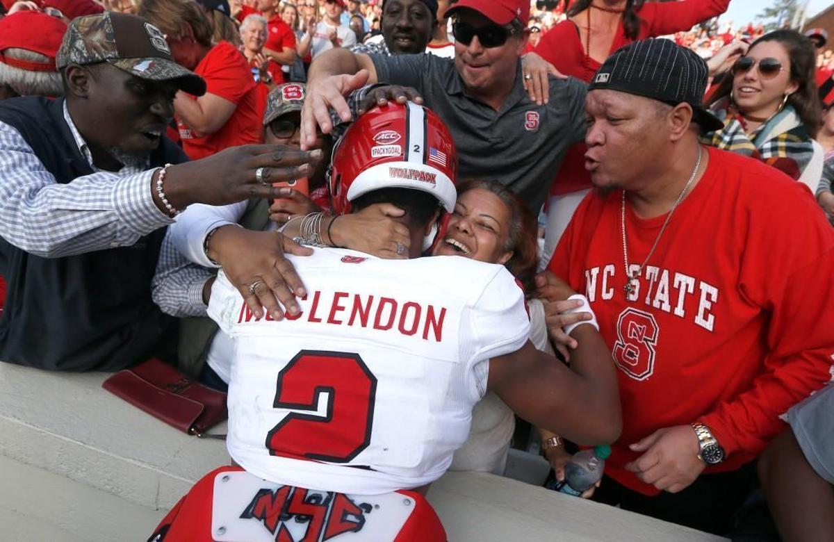 N.C. State quarterback Jalan McClendon is hugged by his stepmother Latrenda Richardson as his dad, Phil McClendon, right, looks on after the Wolfpack beat UNC 28-21 in November.