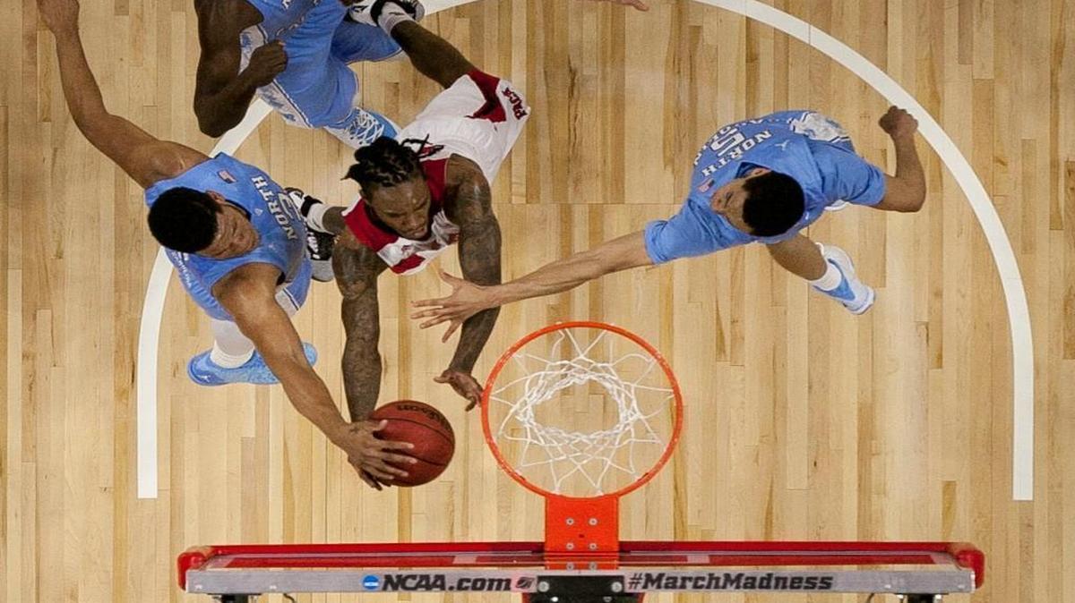 Cat Barber drives to the basket against Kennedy Meeks (3) and Marcus Paige (5) in the first half.