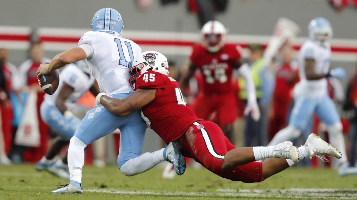N.C. State defensive end Darian Roseboro (45) sacks North Carolina quarterback Nathan Elliott (11) during the first half of N.C. State's game against UNC at Carter-Finley Stadium in Raleigh, N.C., Saturday, Nov. 25, 2017.