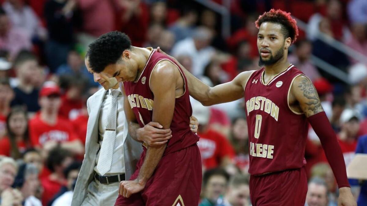 Boston College's Ky Bowman (0), right, helps Jerome Robinson (1) come off the court after he was injured during the first half of N.C. State's game against Boston College at PNC Arena in Raleigh on Tuesday, Feb. 20, 2018.