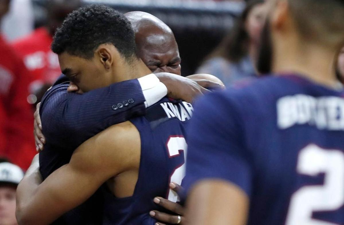 South Carolina State head coach Murray Garvin hugs Ian Kinard (24) as Ty Solomon is attended to during the first half of N.C. State's game against South Carolina State at PNC Arena on Dec. 2, 2017.