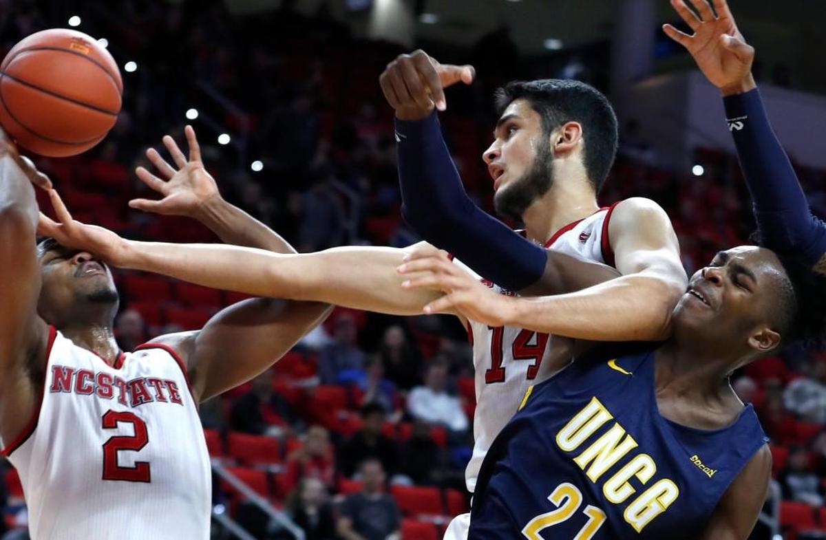 N.C. State's Omer Yurtseven (14), center, goes after the rebound with UNC Greensboro's James Dickey (21) and N.C. State's Torin Dorn (2) during UNCG's 81-76 victory.