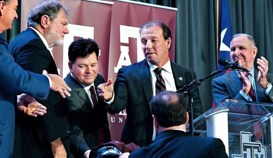 Jimbo Fisher, second from right, reaches out to shake the hand of Texas A&M Chancellor John Sharp, far left, when Fisher was introduced as the Aggies’ new coach on Dec. 4. Fisher left Florida State to take a six-year, $36 million deal that averages $6 million per season at Texas A&M.