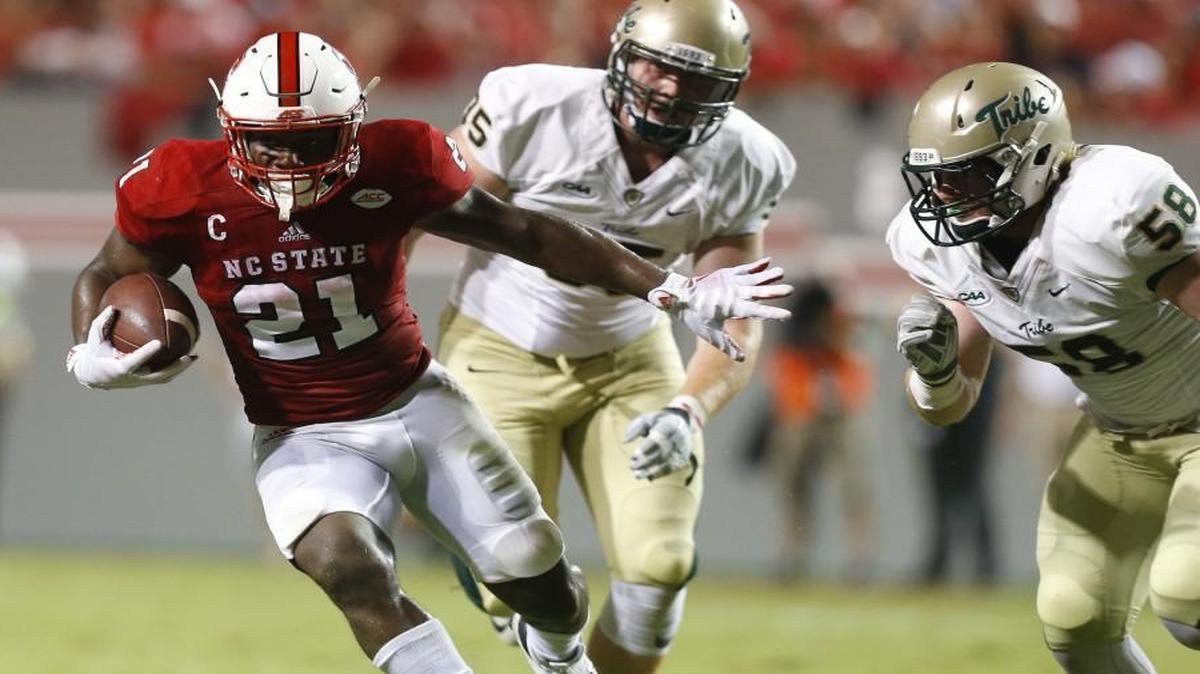 N.C. State running back Matthew Dayes gains yards as William & Mary's defensive end Matt Ahola (58) closes in during the first half at Carter-Finley Stadium in Raleigh.