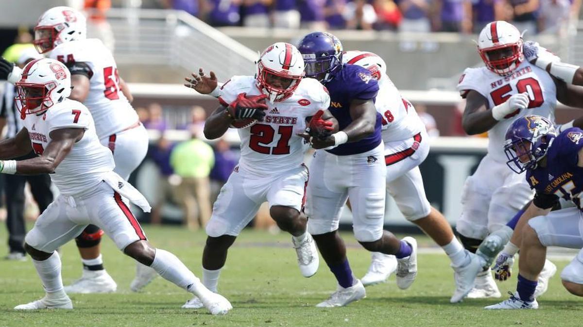 N.C. State running back Matt Dayes breaks through the ECU defense for a gain during the second half of the Pirates’ 33-30 victory over the Wolfpack on Saturday.