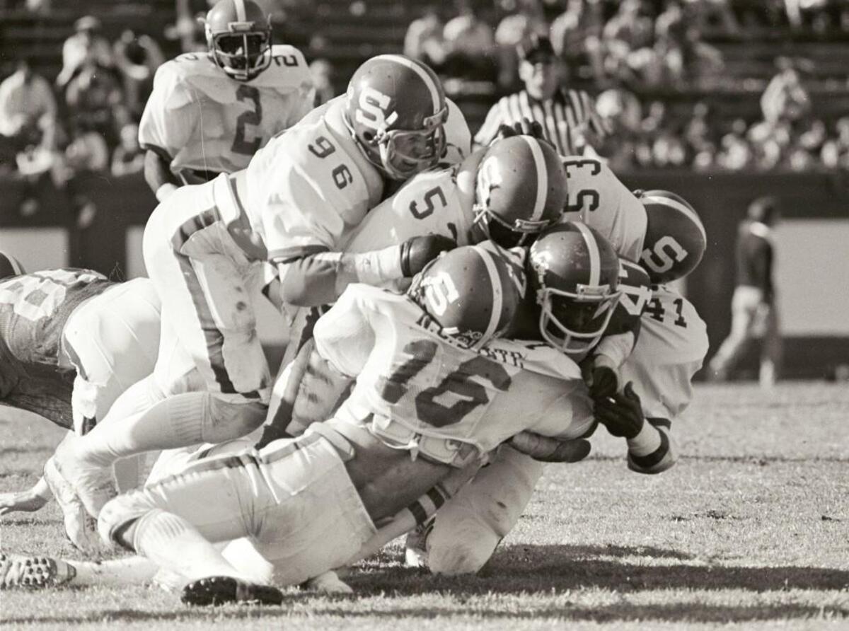 N.C. State’s Mike Nall (16), David Horning (96), Robert Abraham (53) and Steve Binder (41) tackle Duke’s Greg Rhett during their game on Nov. 17, 1979. State won the game 28-7.