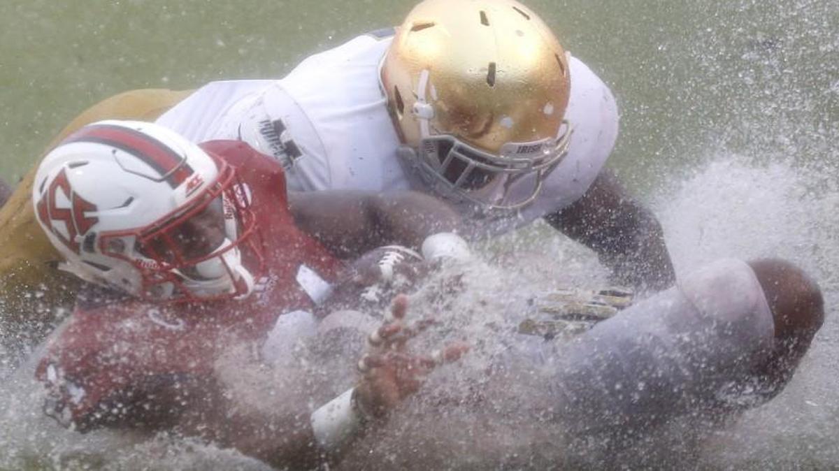 N.C. State running back Matt Dayes (21) slides on the ground after being tackled by Notre Dame linebacker Te'von Coney (4) during the second half at Carter-Finley Stadium.