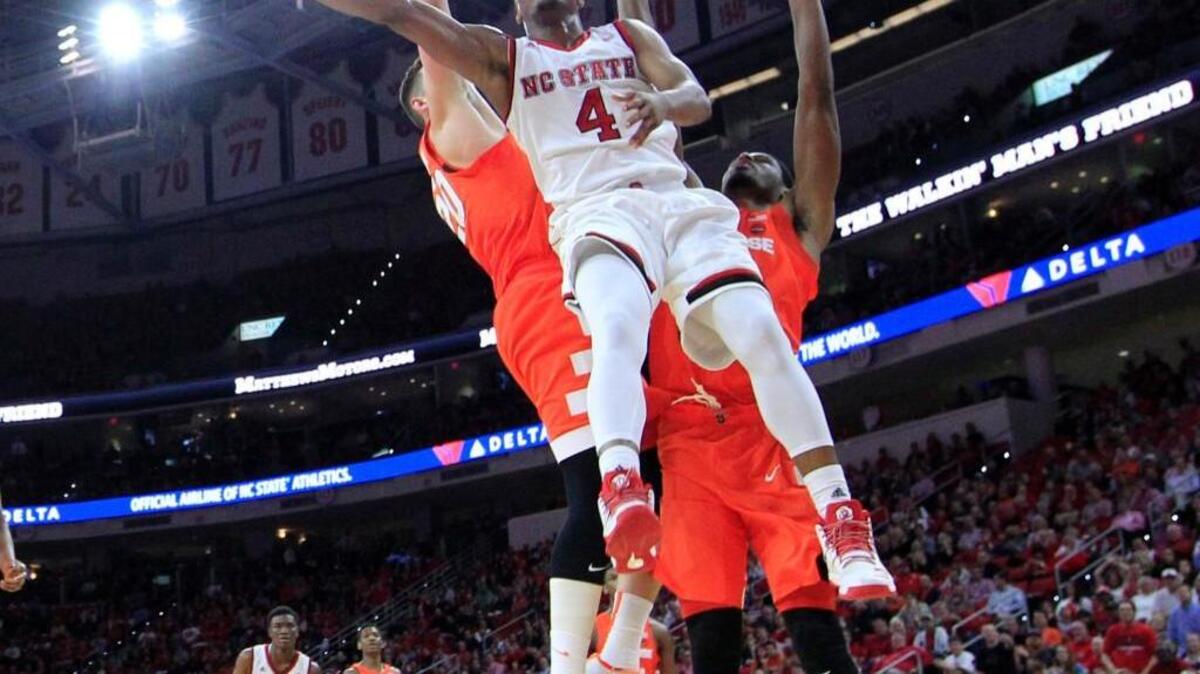 N.C. State's Dennis Smith Jr. (4) makes a basket as Syracuse's Tyler Lydon (20) and Taurean Thompson (12) guard him in the second half during Syracuse's 100-93 overtime victory over N.C. State at PNC Arena in Raleigh, N.C., Wednesday, Feb. 1, 2017.