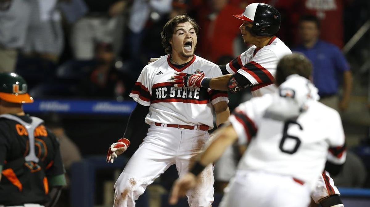 
N.C. State's Preston Palmeiro (12), center, celebrates after scoring in the 12th inning to give the Wolfpack a 5-4 victory over Miami in 12 innings in the ACC Baseball Tournament at the Durham Bulls Athletic Park in Durham,.
