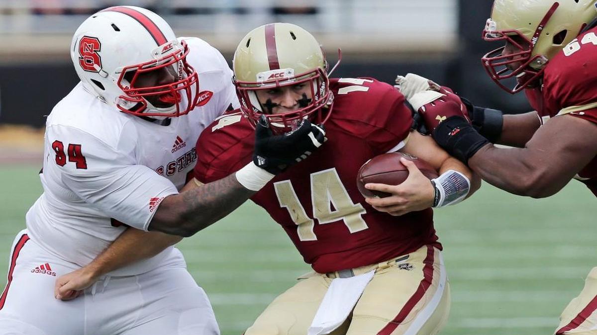 Boston College quarterback John Fadule (14) is taken down by N. C. State safety Dexter Wright (34) during the first half.