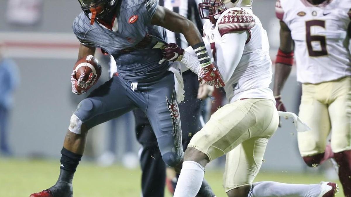 N.C. State’s Nyheim Hines, left, escapes from Florida State’s Ermon Lane, middle, during the Wolfpack’s game against FSU in 2016.
