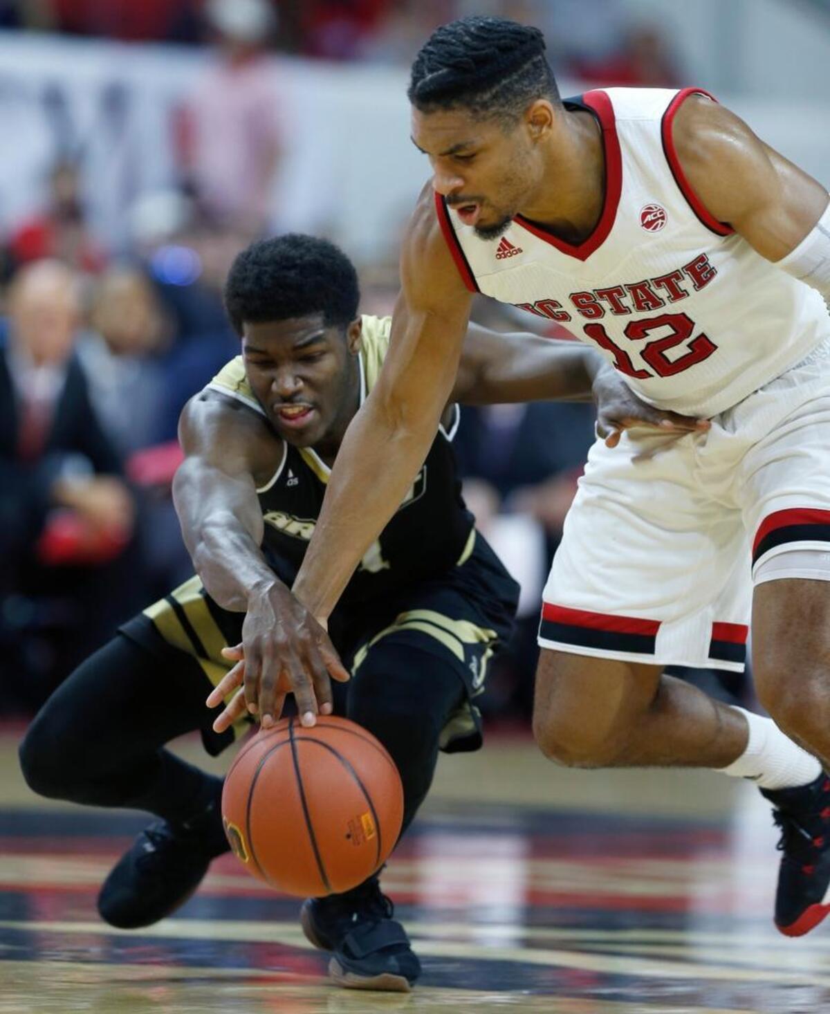 N.C. State's Allerik Freeman (12) tries to steal the ball from Bryant's Adam Grant (11) at PNC Arena Tuesday, Nov. 14, 2017.