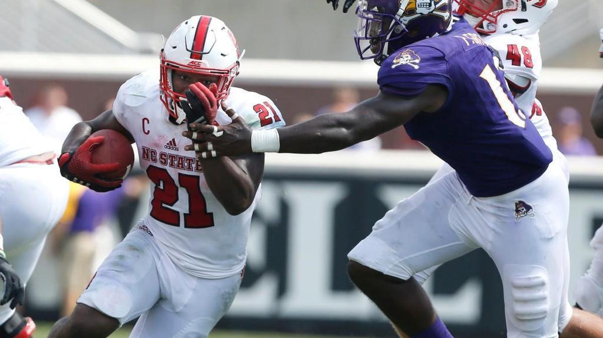 N.C. State running back Matt Dayes, left, gets past East Carolina linebacker Pat Green as N.C. State’s Cole Cook blocks during the Pirates’ 33-30 win over the Wolfpack on Sept. 10.