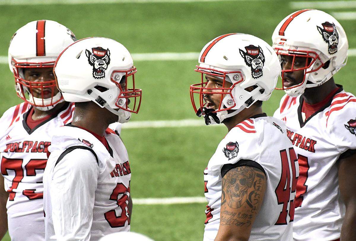 N.C. State’s Darian Roseboro (45) and teammate Dexter Wright (14) speak with teammates during the first day of practice at the Wolfpack’s indoor practice facility in Raleigh, N.C., Friday, Aug. 3, 2018.