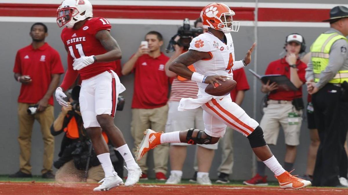 Clemson quarterback Deshaun Watson (4) runs past N.C. State's Juston Burris (11) to score on a 24-yard rushing touchdown during the first half at Carter-Finley Stadium.
