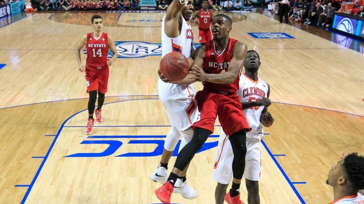 N.C. State's Dennis Smith Jr. (4) drives to the basket past Clemson's Jaron Blossomgame (5) and Sidy Djitte (50) during Clemson's 75-61 victory over N.C. State at the ACC tournament at the Barclays Center in Brooklyn, N.Y., on March 7, 2017.