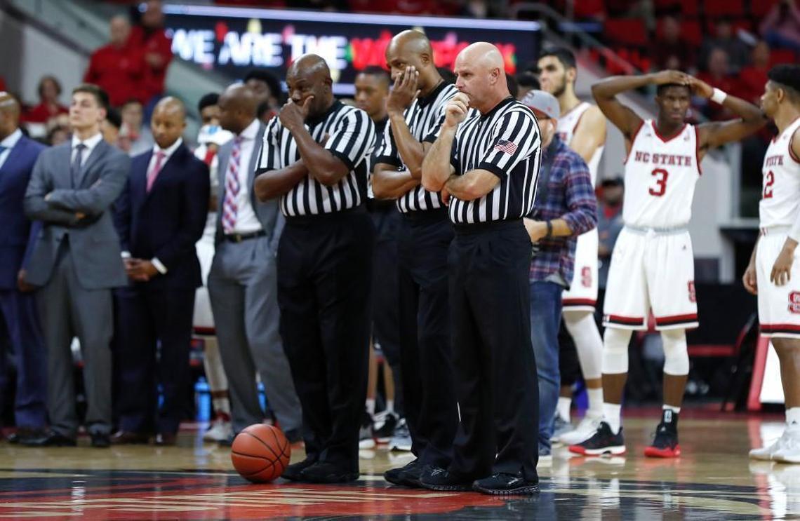 Officials, left, Les Jones, Bert Smith and Tim Comer, watch as South Carolina State’s Tyvoris Solomon is attended to after he collapsed during a game against N.C. State on Dec. 2.