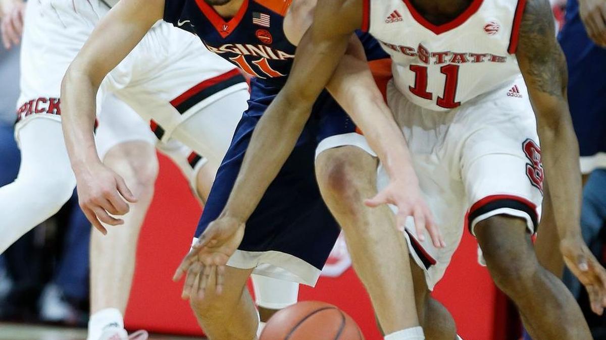 N.C. State's Markell Johnson (11), right, beats Virginia's Ty Jerome to the loose ball during the first half of game against Virginia at PNC Arena on Feb. 25, 2017. Johnson injured his knee against Clemson Wednesday night.