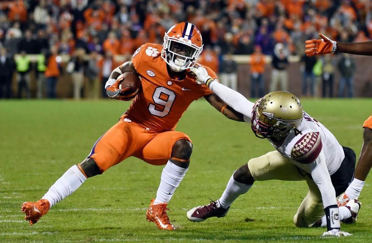 Clemson running back Travis Etienne (9) runs for yardage as Florida State defensive back Tarvarus McFadden (4) defends during the second half on Nov. 11, 2017, in Clemson, S.C. (AP Photo/Rainier Ehrhardt)