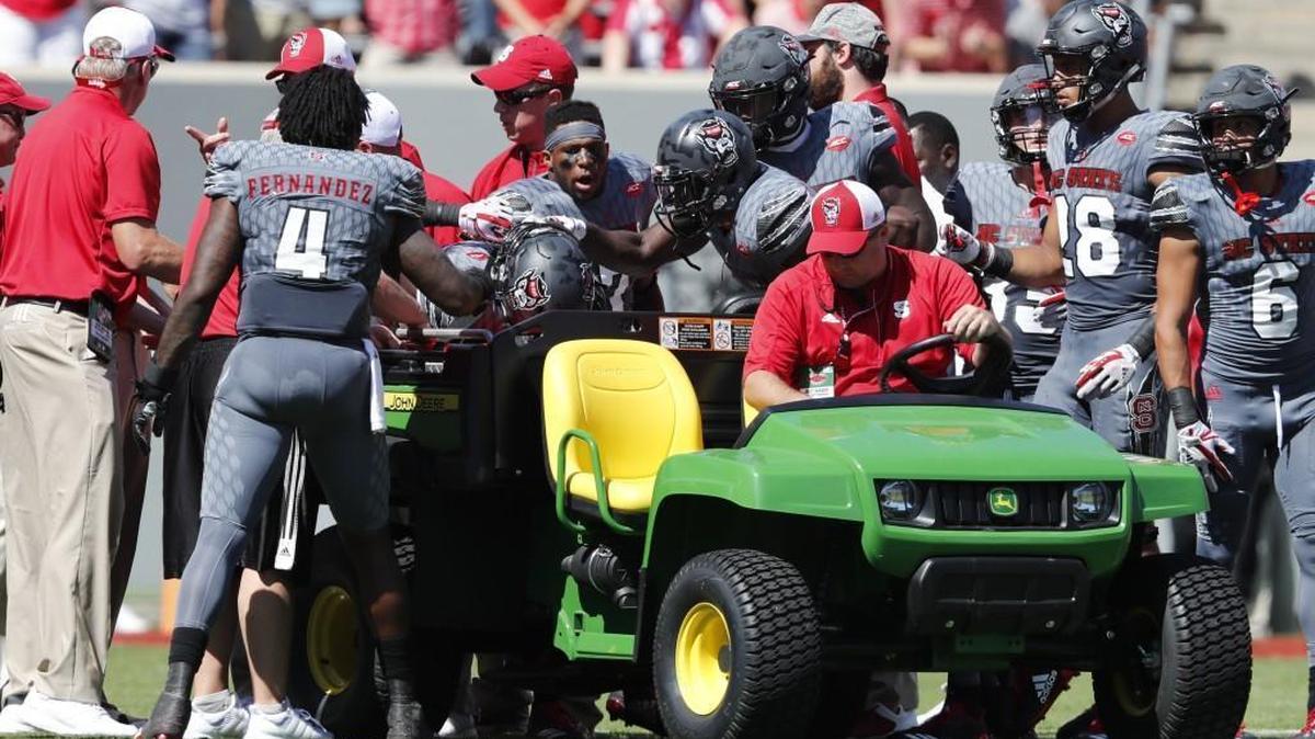 Teammates check on Dakwa Nichols before he is taken off the field during the first half of N.C. State's game against Syracuse at Carter-Finley Stadium in Raleigh, N.C. Saturday, Sept. 30, 2017.