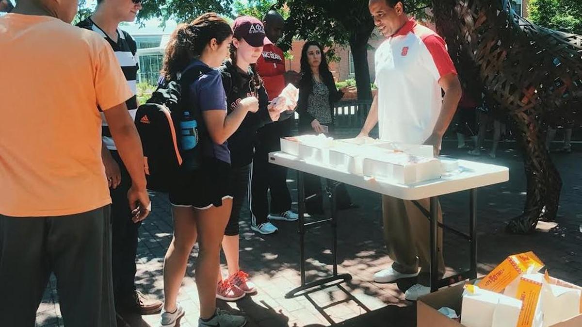 NC State basketball coach Kevin Keatts hands out biscuits on campus on Tuesday.