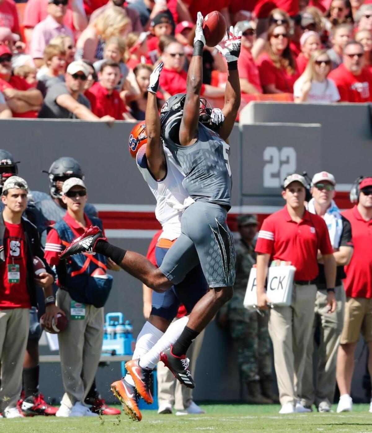 N.C. State cornerback Johnathan Alston (5) intercepts a ball intended for Syracuse wide receiver Devin C. Butler (5) during the first half at Carter-Finley Stadium in Raleigh Saturday, Sept. 30, 2017.