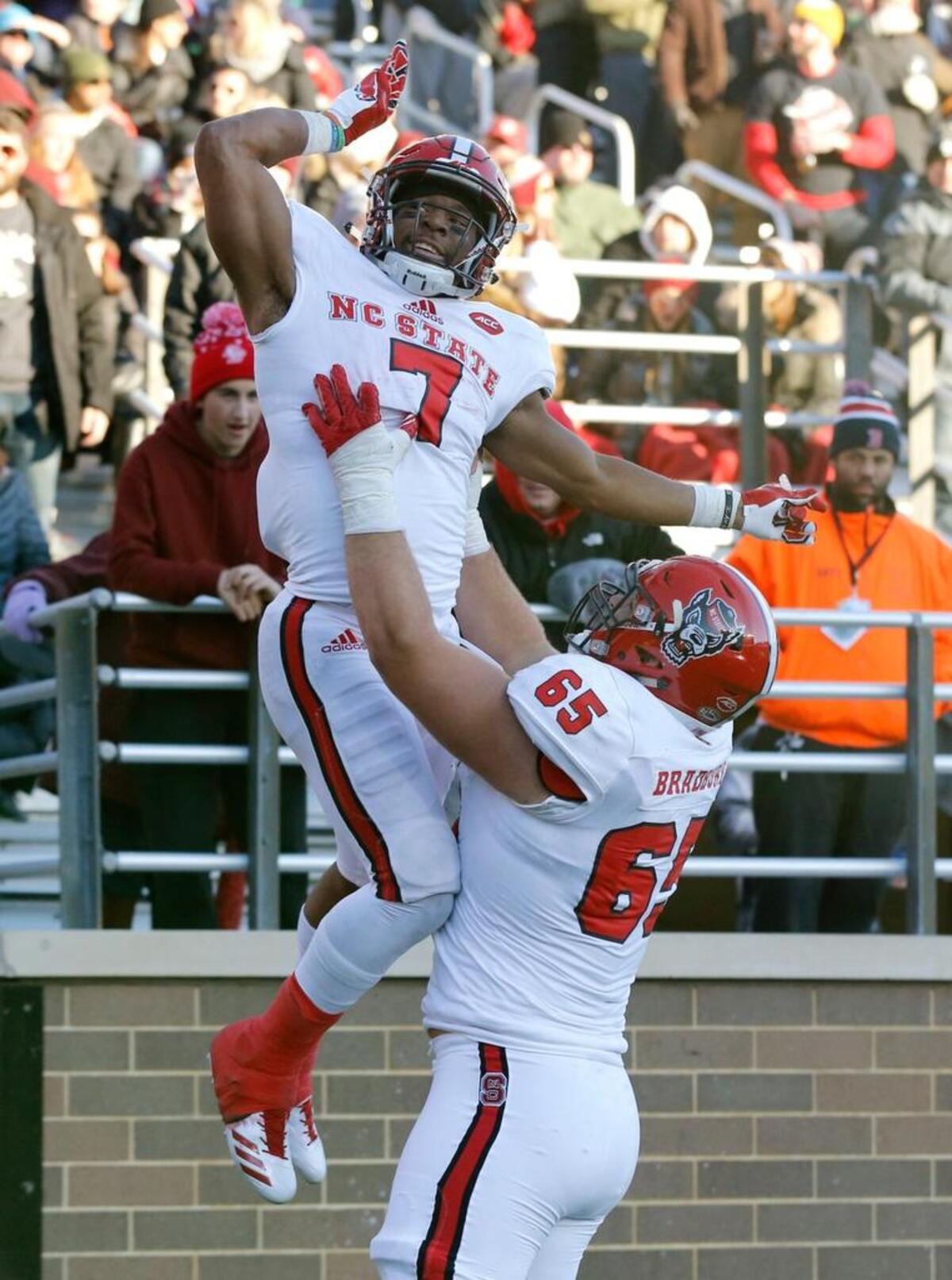 N.C. State's Nyheim Hines (7) celebrates with Garrett Bradbury (65) after scoring on a 50-yard touchdown run at Alumni Stadium in Chestnut Hill Saturday, Nov. 11, 2017.