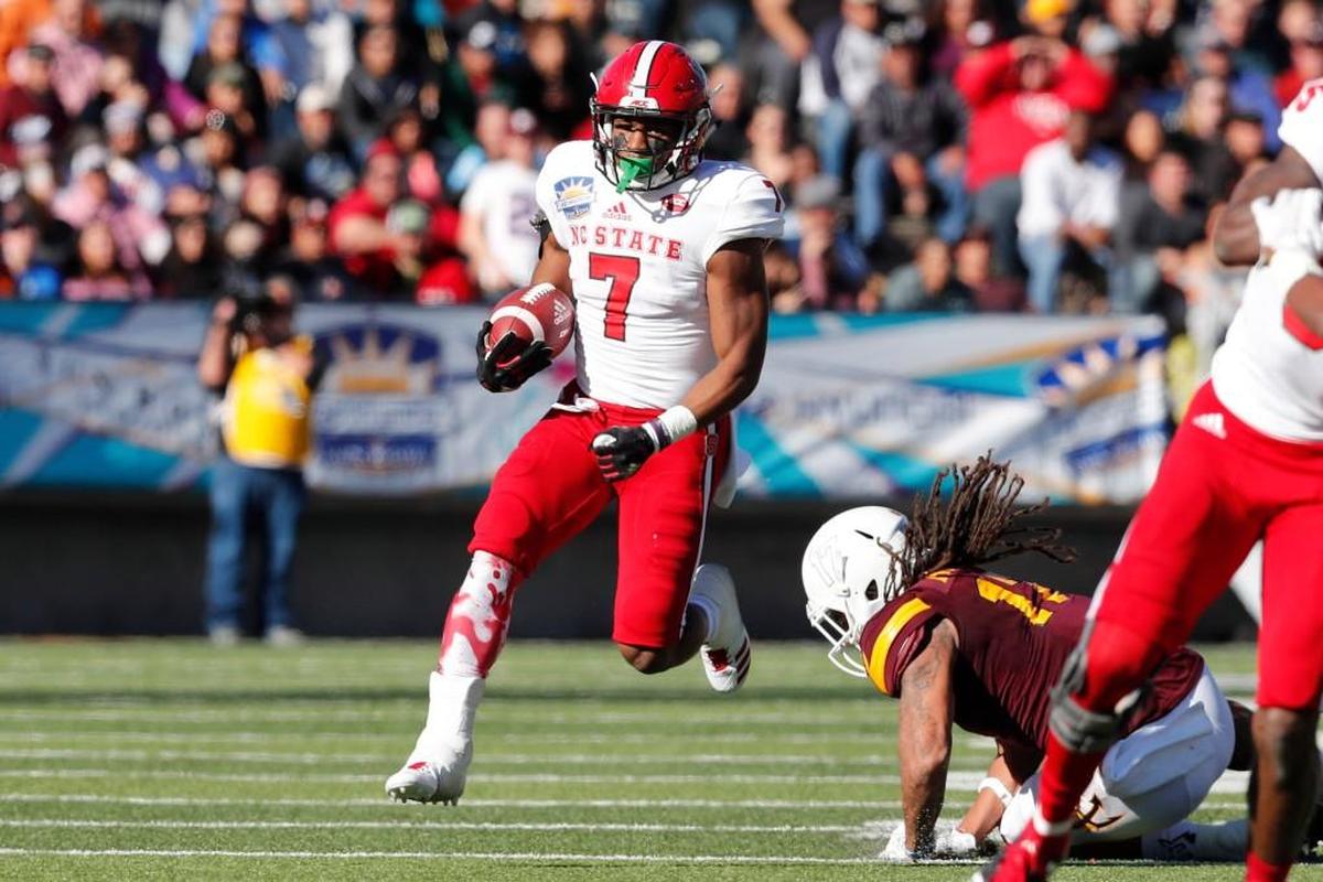 N.C. State running back Nyheim Hines beats Arizona State defensive back J’Marcus Rhodes, right, on a long run during the first half of the Sun Bowl on Friday. Hines had three touchdowns in the first half.