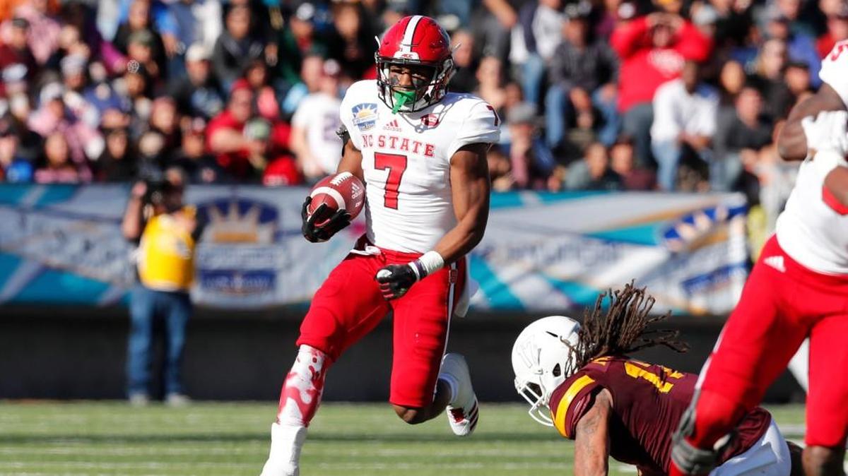 N.C. State running back Nyheim Hines beats Arizona State defensive back J’Marcus Rhodes, right, on a long run during the first half of the Sun Bowl on Friday. Hines had three touchdowns in the first half.