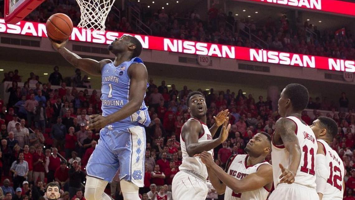 North Carolina’s Theo Pinson, left, breaks to the basket past N.C. State’s Abdul-Malik Abu, middle, in UNC’s 96-89 win over the Wolfpack on Feb. 10.