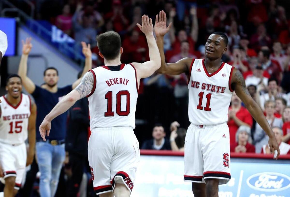 N.C. State's Braxton Beverly (10) celebrates with Markell Johnson (11) during a timeout during the Wolfpack’s victory over Boston College at PNC Arena in Raleigh Tuesday, Feb. 20, 2018.