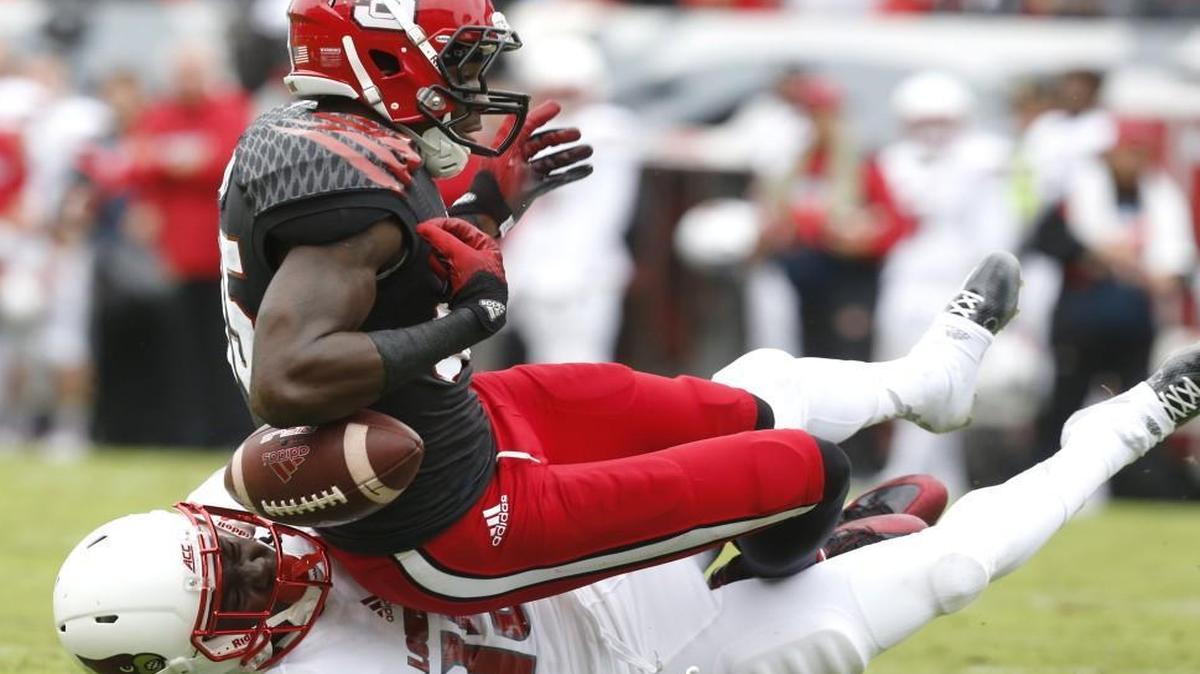 
N.C. State's Jumichael Ramos (85) fumbles while being hit by Louisville cornerback Trumaine Washington (15) during the first half at Carter-Finley Stadium in Raleigh. Louisville would recover the fumble.
