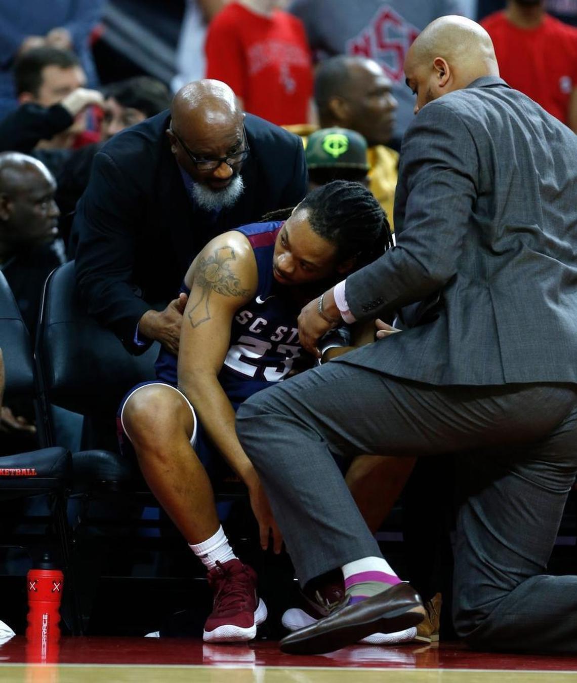 S.C. State’s Tyvoris Solomon is attended to by S.C. State character coach Dr. Jerome Jones, left, and associate men’s basketball coach Rio Pitt before Solomon collapsed on Dec. 2.