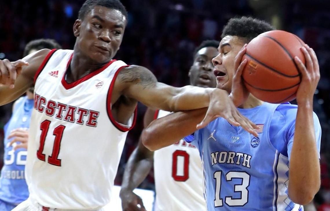 North Carolina's Cameron Johnson (13) drives around N.C. State's Markell Johnson (11) during the first half of N.C. State's loss to UNC.