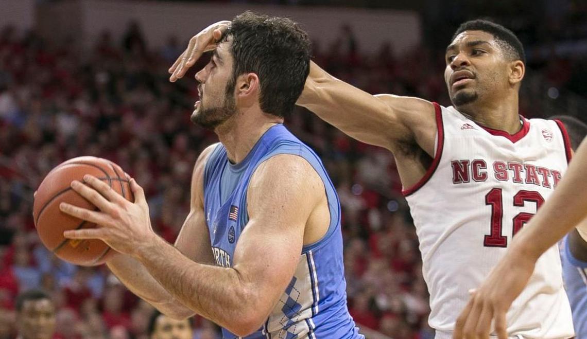 N.C. Stateís Allerik Freeman (12) gets a hand in the face of North Carolinaís Luke Maye (32) during the second half of the Wolfpack’s loss to the Tar Heels.