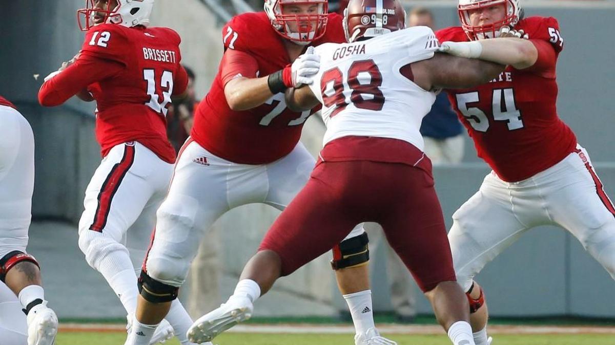 
N.C. State's Alex Barr (71) and Joe Thuney (54) block Troy defensive lineman Lonnie Gosha (98) to give quarterback Jacoby Brissett (12) time to pass during the Wolfpack's game against Troy at Carter-Finley Stadium in Raleigh Saturday, Sept. 5, 2015.
