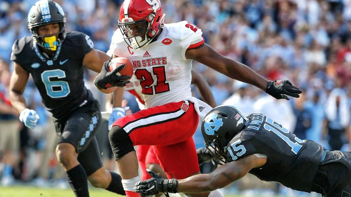 N.C. State running back Matt Dayes (21) beats North Carolina safety Donnie Miles (15) on 18-yard touchdown run during Wolfpack's win against UNC at Kenan Stadium on Nov. 25, 2016.