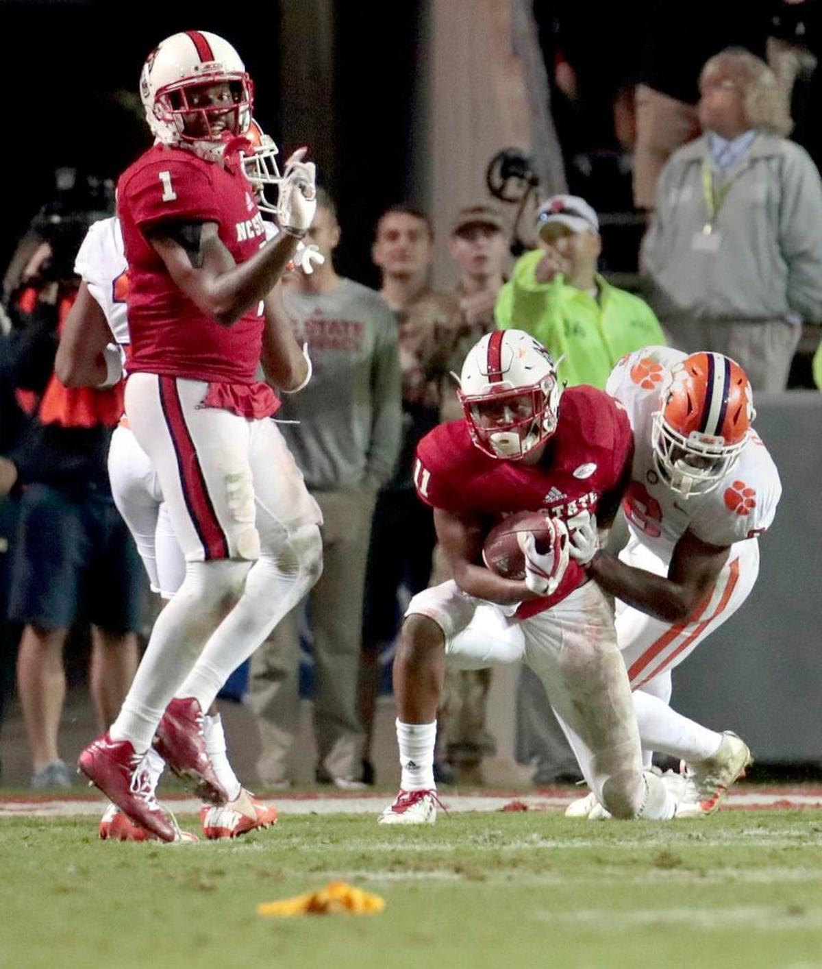 N.C. State's Jaylen Samuels (1) looks back at a penalty flag as Jakobi Meyers (11) gets up after being upended by Clemson's Dorian O'Daniel (6) after a catch late in the fourth quarter.