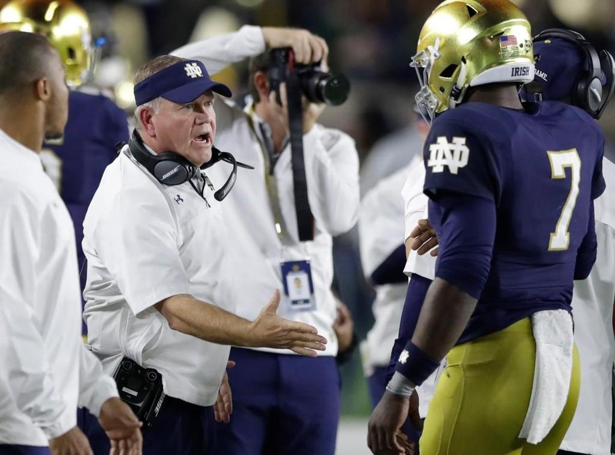 Notre Dame coach Brian Kelly reaches out to quarterback Brandon Wimbush (7) after Wimbush scored against Southern California, Saturday, Oct. 21, 2017, in South Bend, Ind. Notre Dame won 49-14.